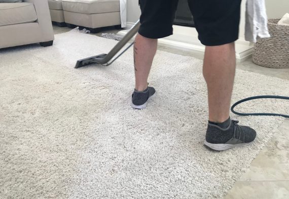 a-man-cleans-the-white-shag-carpet-at-home_t20_8d9o86